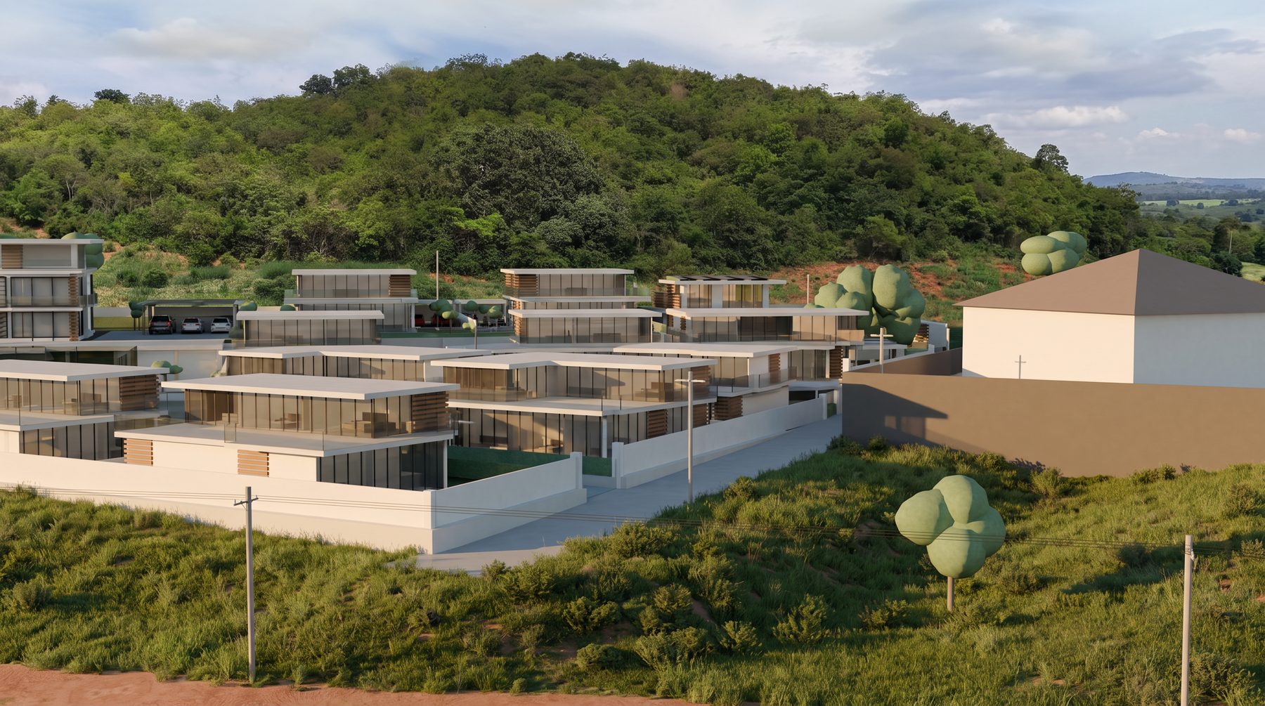 The terraces of villas in the afternoon, rising row above row, with the forested hill behind